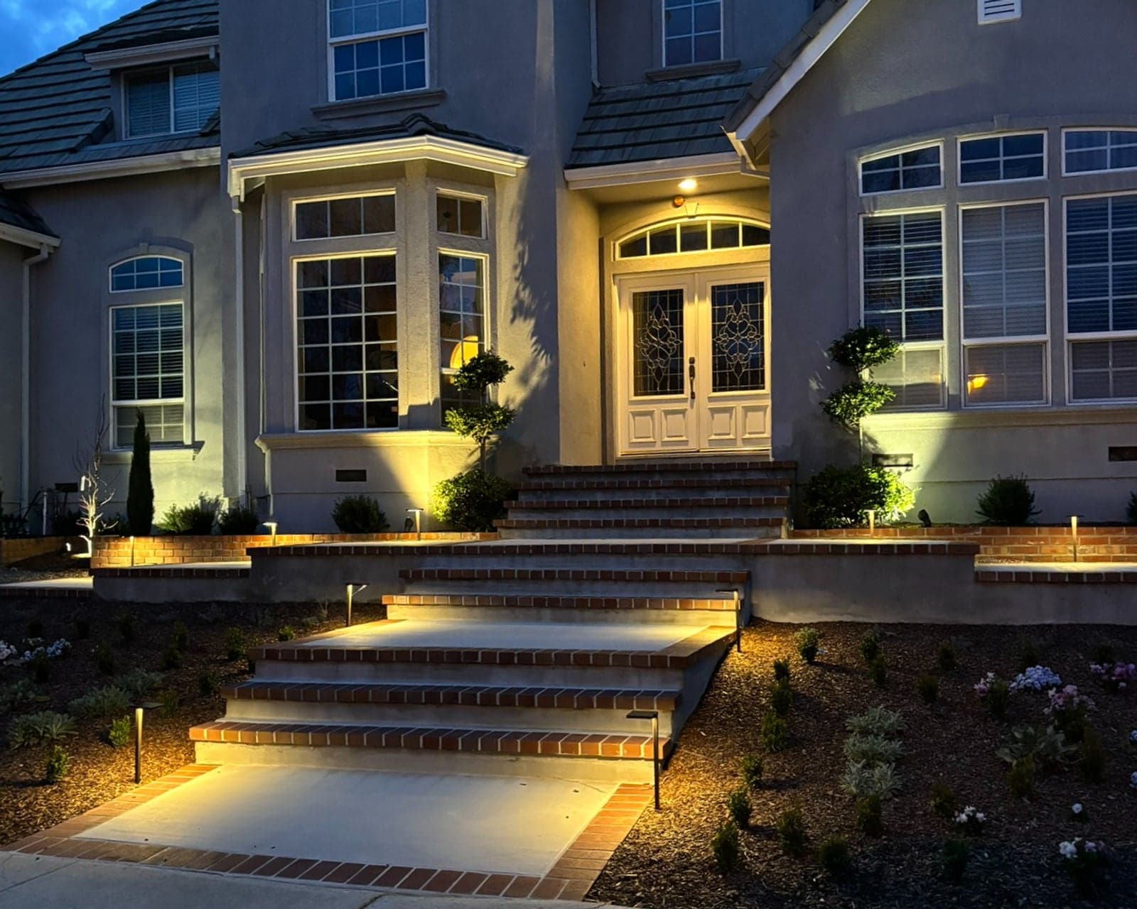 Front entry steps and planting beds illuminated with low-voltage landscape lighting
